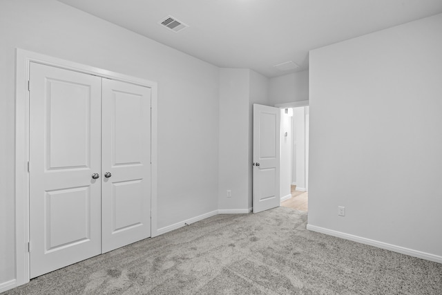 unfurnished bedroom with a closet and light colored carpet