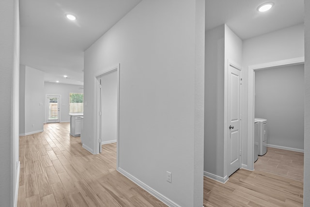 corridor featuring washer and clothes dryer and light hardwood / wood-style floors