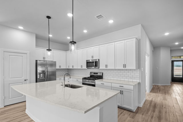 kitchen with white cabinets, stainless steel appliances, sink, and hanging light fixtures