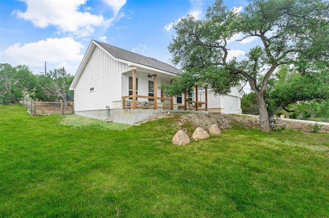 rear view of property featuring a yard and a garage