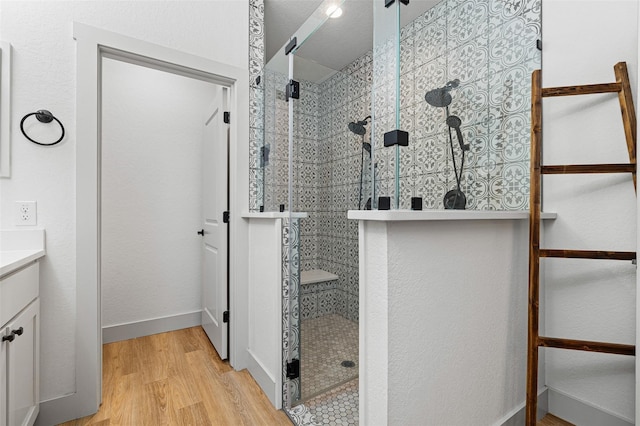 bathroom featuring hardwood / wood-style flooring, vanity, and an enclosed shower