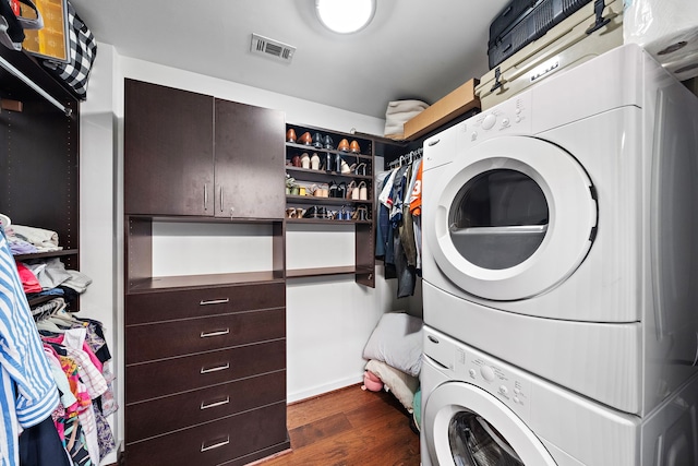 laundry area featuring dark hardwood / wood-style flooring and stacked washer and dryer