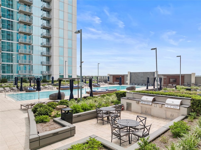 view of community featuring a patio, exterior kitchen, and a swimming pool