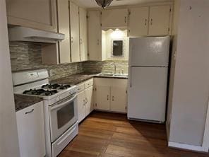 kitchen with decorative backsplash, sink, white appliances, and white cabinetry