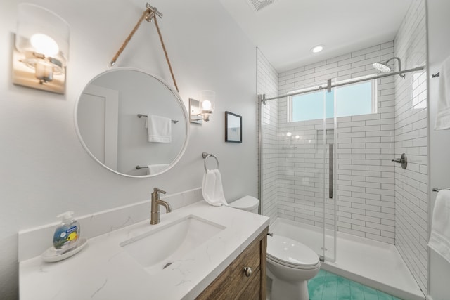 bathroom with vanity, toilet, and a shower with shower door