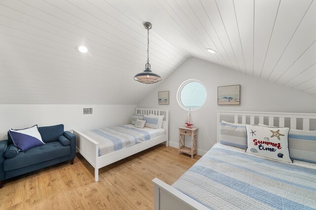 bedroom with vaulted ceiling, wooden ceiling, and light hardwood / wood-style flooring