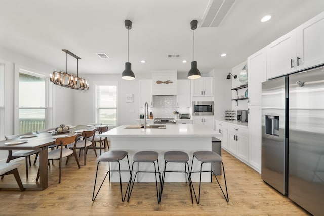 kitchen featuring white cabinets, appliances with stainless steel finishes, sink, and a healthy amount of sunlight