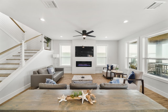 living room with a fireplace, hardwood / wood-style floors, and ceiling fan