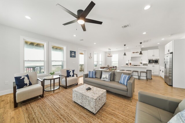 living room with light wood-type flooring and ceiling fan