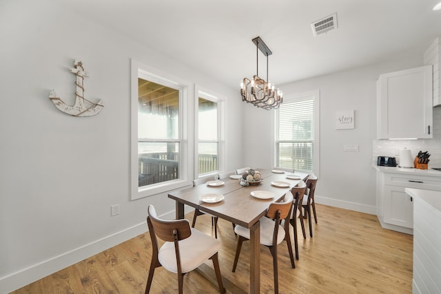 dining room with a notable chandelier and light hardwood / wood-style flooring