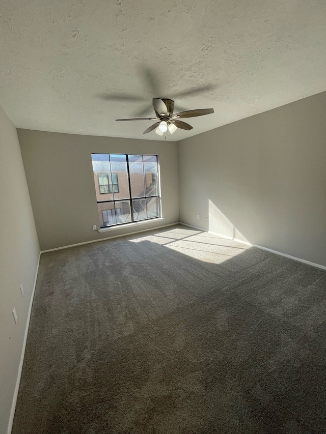 empty room featuring a textured ceiling, carpet flooring, and ceiling fan