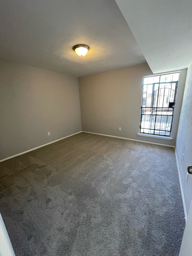 unfurnished room featuring a textured ceiling and carpet