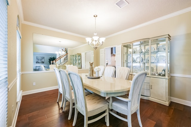 dining room featuring ornamental molding, a chandelier, dark wood-type flooring, and a textured ceiling