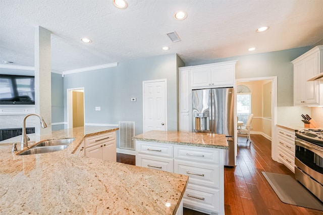 kitchen featuring sink, white cabinets, appliances with stainless steel finishes, light stone counters, and dark hardwood / wood-style flooring