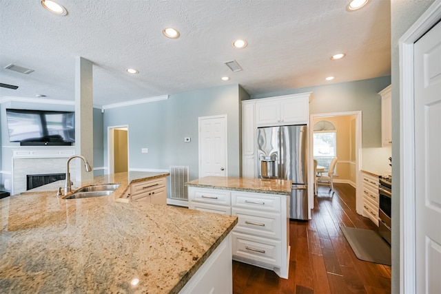 kitchen with light stone counters, white cabinetry, dark wood-type flooring, sink, and stainless steel appliances