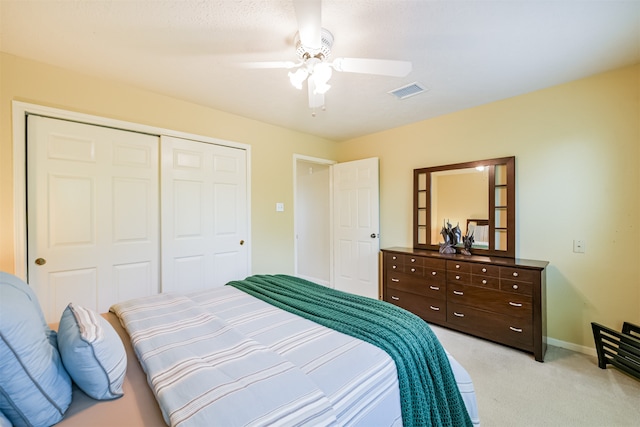 bedroom with light colored carpet, a closet, and ceiling fan