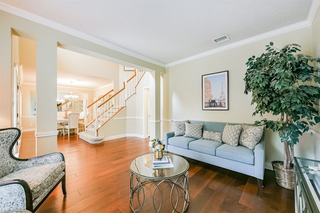 living room with ornamental molding, hardwood / wood-style flooring, and an inviting chandelier