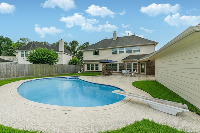 view of pool featuring a patio area and a diving board