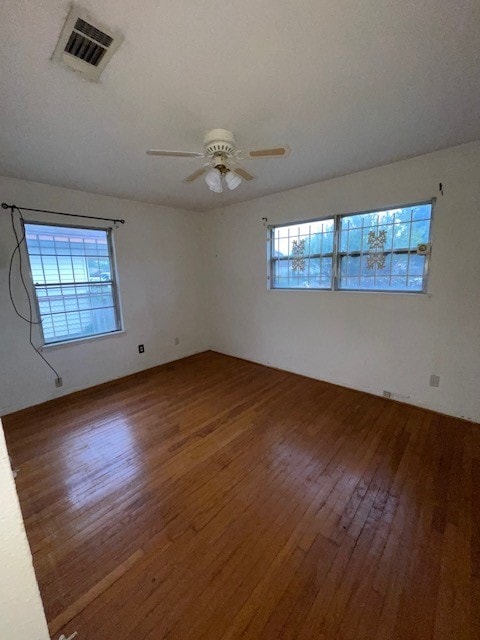 empty room featuring ceiling fan and dark hardwood / wood-style flooring