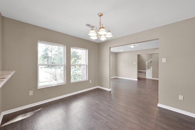 unfurnished dining area featuring dark wood-type flooring and a notable chandelier