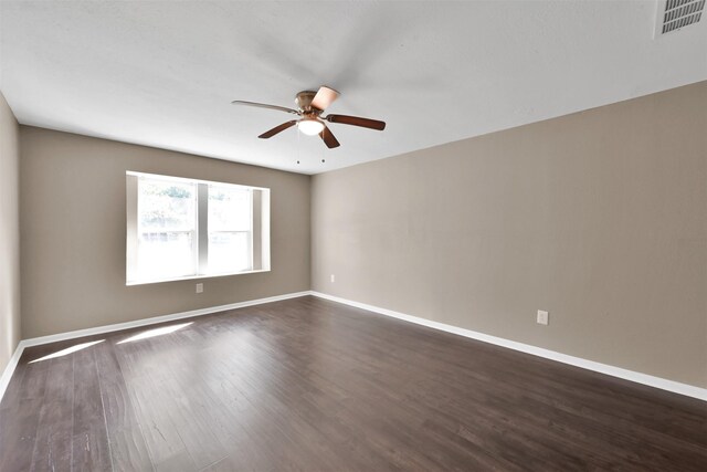 696 Ravensworth Dr, Conroe, TX 77302 - empty room with dark wood-style flooring, visible vents, ceiling fan, and baseboards