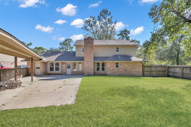 696 Ravensworth Dr, Conroe, TX 77302 - rear view of house featuring a shingled roof, a yard, a patio area, a chimney, and a fenced backyard