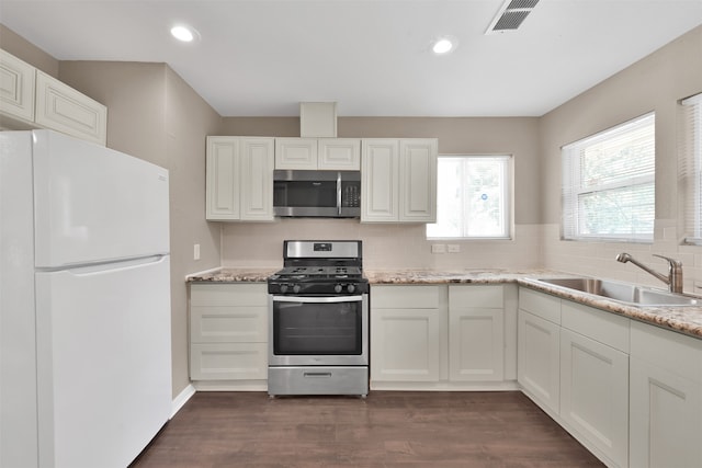 kitchen featuring appliances with stainless steel finishes, white cabinetry, dark wood-type flooring, and sink