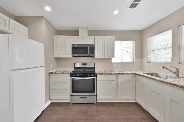 696 Ravensworth Dr, Conroe, TX 77302 - kitchen with tasteful backsplash, white cabinetry, visible vents, a sink, and stainless steel appliances