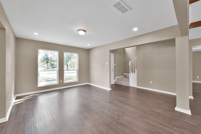 696 Ravensworth Dr, Conroe, TX 77302 - unfurnished living room with stairs, visible vents, baseboards, and dark wood-style floors