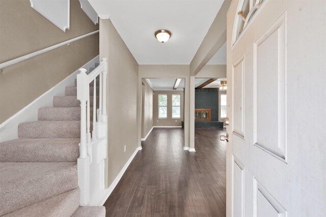 696 Ravensworth Dr, Conroe, TX 77302 - foyer with baseboards, a ceiling fan, stairs, a brick fireplace, and dark wood finished floors