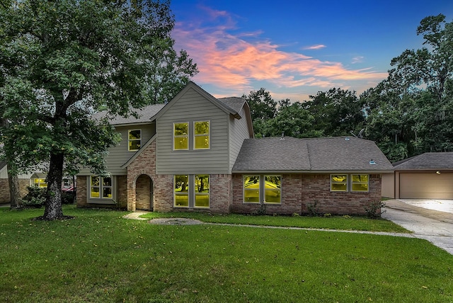 696 Ravensworth Dr, Conroe, TX 77302 - traditional-style house with concrete driveway, a front yard, brick siding, a garage, and a shingled roof