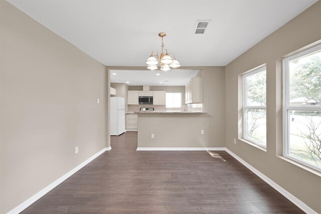 696 Ravensworth Dr, Conroe, TX 77302 - unfurnished dining area with a wealth of natural light, dark wood-type flooring, baseboards, and an inviting chandelier