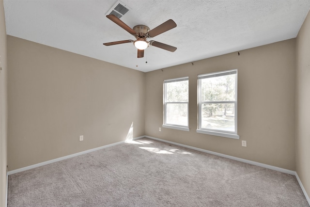 carpeted spare room with ceiling fan and a textured ceiling