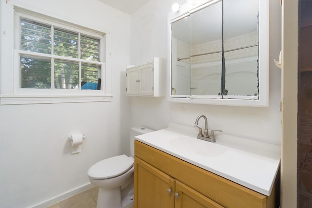 bathroom featuring vanity, a tile shower, toilet, and tile patterned floors