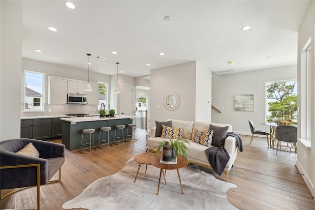 living room with sink and light wood-type flooring