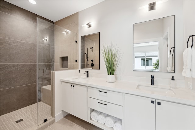 bathroom with vanity, a tile shower, and tile patterned flooring