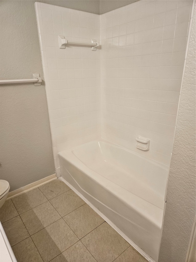 bathroom with bathtub / shower combination, toilet, and tile patterned flooring