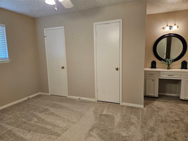 unfurnished bedroom with light carpet, a textured ceiling, and ceiling fan