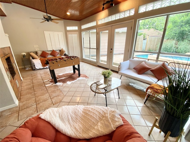 sunroom / solarium featuring ceiling fan, wooden ceiling, plenty of natural light, and vaulted ceiling