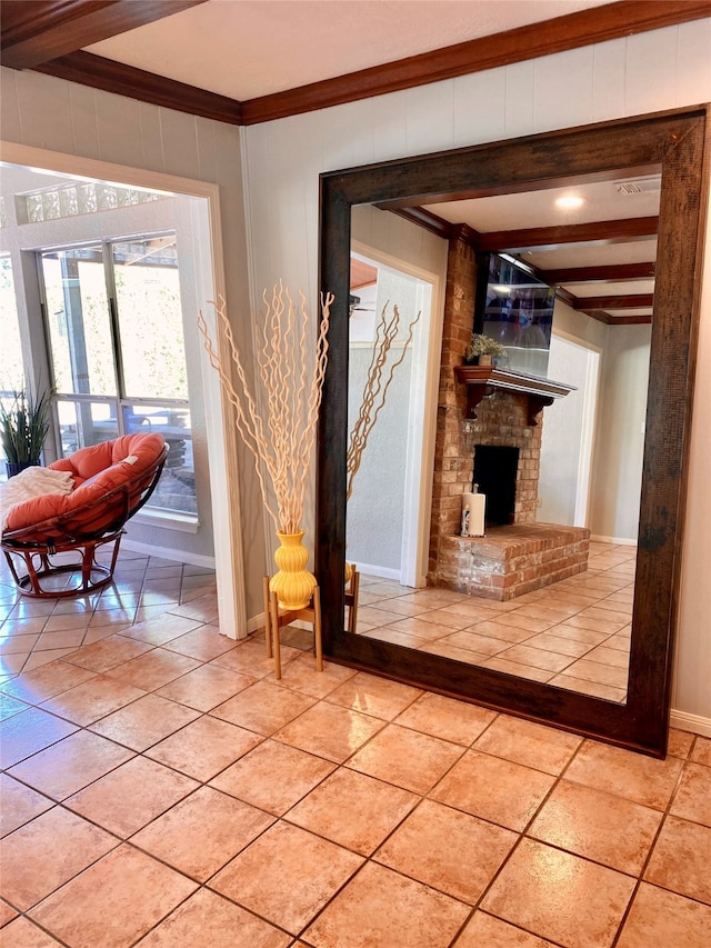 living room with crown molding, beamed ceiling, a fireplace, and light tile patterned floors