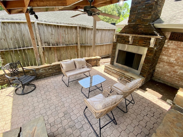 view of patio featuring an outdoor stone fireplace and ceiling fan