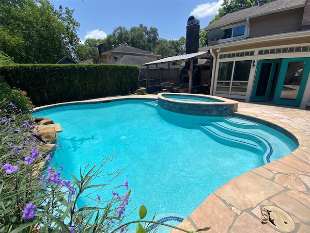 view of swimming pool with an in ground hot tub