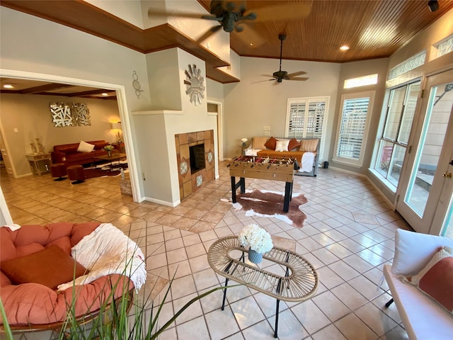 living room featuring wood ceiling, a tile fireplace, ceiling fan, crown molding, and light tile patterned floors