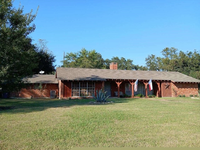 ranch-style house featuring a front yard and central air condition unit