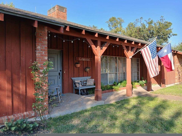 view of exterior entry featuring a lawn