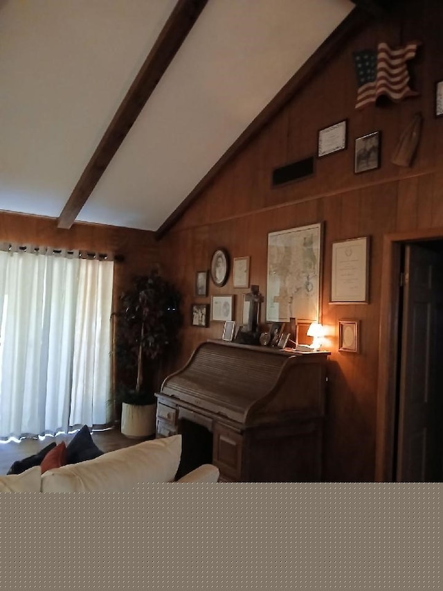 rec room with lofted ceiling with beams and wood walls