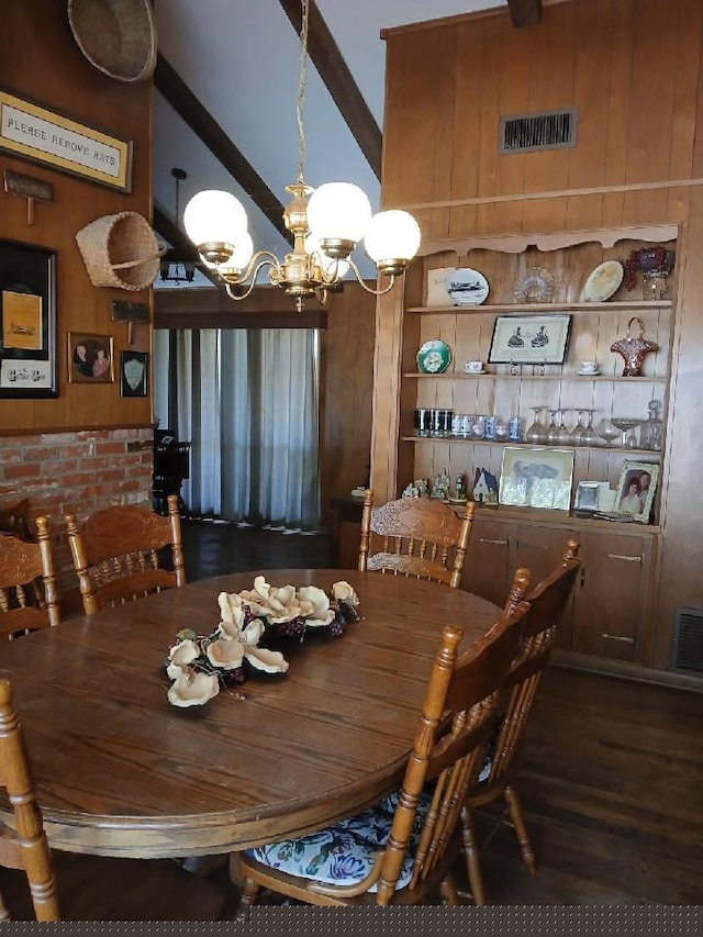 dining space featuring wood walls, a chandelier, and dark hardwood / wood-style flooring