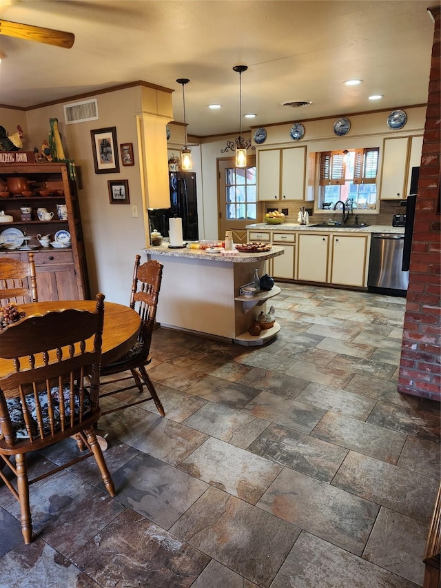 kitchen with pendant lighting, sink, dishwasher, black fridge, and kitchen peninsula