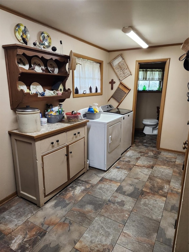 clothes washing area with cabinets, ornamental molding, and washer and dryer