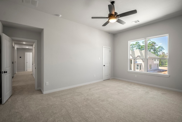 spare room featuring light carpet and ceiling fan